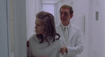 Movie still from “Puzzle of a Downfall Child” (1970), directed by Jerry Schatzberg – A man and a woman in white lab coats in a room; Medium shot, Low angle