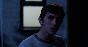 Movie still from “Quadrophenia” (1979), directed by Franc Roddam – A young man in a white shirt is looking at the camera; Close Up shot, Over the shoulder angle