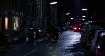 Movie still from “Quadrophenia” (1979), directed by Franc Roddam – A street scene with a person riding a motorcycle; Extreme Wide shot, Low angle