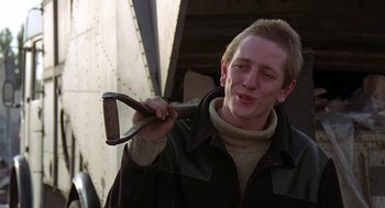 Movie still from “Quadrophenia” (1979), directed by Franc Roddam – A young man holding a large wrench in his hand; Close Up shot, Over the shoulder angle