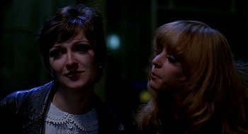 Movie still from “Quadrophenia” (1979), directed by Franc Roddam – Two women standing next to each other in the dark; Close Up shot, Over the shoulder angle