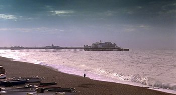 Movie still from “Quadrophenia” (1979), directed by Franc Roddam – A person standing on a beach near the ocean; Extreme Wide shot, High angle
