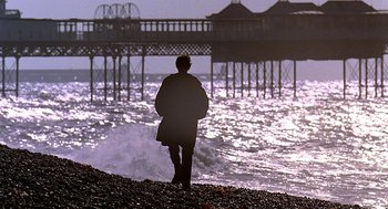 Movie still from “Quadrophenia” (1979), directed by Franc Roddam – A man standing on a beach near the ocean; Wide shot, Low angle