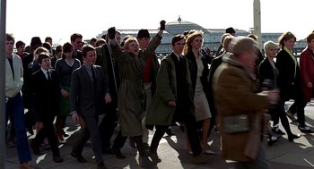 Movie still from “Quadrophenia” (1979), directed by Franc Roddam – A group of people walking down a street; Wide shot, High angle