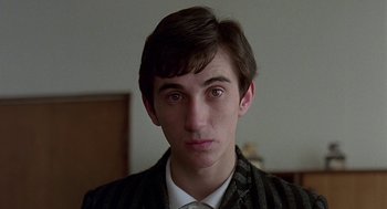 Movie still from “Quadrophenia” (1979), directed by Franc Roddam – A young man in a suit and tie looking at the camera; Close Up shot, Low angle