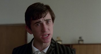 Movie still from “Quadrophenia” (1979), directed by Franc Roddam – A young man in a striped jacket looking at the camera; Close Up shot, Over the shoulder angle