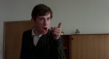 Movie still from “Quadrophenia” (1979), directed by Franc Roddam – A man in a suit is pointing his finger at the camera; Close Up shot, Low angle