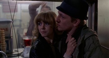 Movie still from “Quadrophenia” (1979), directed by Franc Roddam – A man and a woman standing next to each other; Close Up shot, Over the shoulder angle