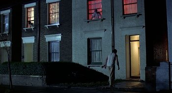 Movie still from “Quadrophenia” (1979), directed by Franc Roddam – A man standing in front of a building at night; Wide shot, Low angle
