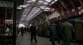 Movie still from “Quadrophenia” (1979), directed by Franc Roddam – A group of people walking around a train station; Extreme Wide shot, High angle