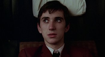 Movie still from “Quadrophenia” (1979), directed by Franc Roddam – A man in a suit and tie looking at the camera; Close Up shot, High angle