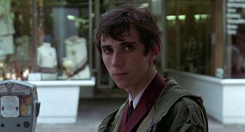Movie still from “Quadrophenia” (1979), directed by Franc Roddam – A young man in a suit and tie in front of a building; Close Up shot, Over the shoulder angle