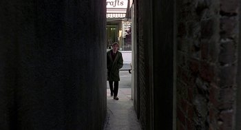 Movie still from “Quadrophenia” (1979), directed by Franc Roddam – A man standing in an open doorway of a building; Wide shot, High angle