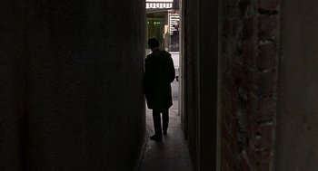Movie still from “Quadrophenia” (1979), directed by Franc Roddam – A person walking down a hallway in the dark; Wide shot, High angle