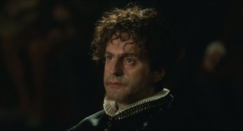 Movie still from “Queen Margot” (1994), directed by Patrice Chéreau – A person wearing a black and white outfit; Close Up shot, Over the shoulder angle