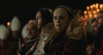 Movie still from “Queen Margot” (1994), directed by Patrice Chéreau – A woman in a red and gold dress and a man in a black and white suit; Close Up shot, Over the shoulder angle