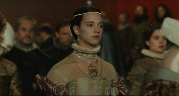 Movie still from “Queen Margot” (1994), directed by Patrice Chéreau – A young woman in a medieval dress with pearls around her neck; Close Up shot, Low angle