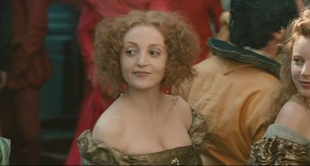 Movie still from “Queen Margot” (1994), directed by Patrice Chéreau – A person with curly hair wearing a dress; Close Up shot, Over the shoulder angle