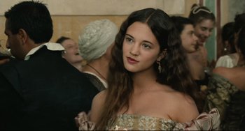 Movie still from “Queen Margot” (1994), directed by Patrice Chéreau – A young woman in a gold dress with long brown hair; Close Up shot, Over the shoulder angle