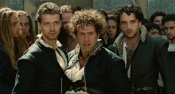 Movie still from “Queen Margot” (1994), directed by Patrice Chéreau – A group of men standing next to each other; Medium shot, Low angle