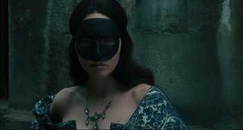 Movie still from “Queen Margot” (1994), directed by Patrice Chéreau – A woman with a black mask on her face; Close Up shot, Over the shoulder angle