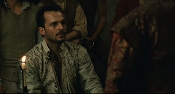 Movie still from “Queen Margot” (1994), directed by Patrice Chéreau – A person wearing a suit and tie; Close Up shot, Over the shoulder angle