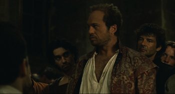 Movie still from “Queen Margot” (1994), directed by Patrice Chéreau – A man with a beard is standing next to another man; Medium shot, Over the shoulder angle