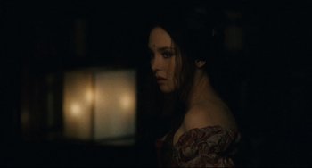 Movie still from “Queen Margot” (1994), directed by Patrice Chéreau – A young woman in a dark room looking at the camera; Close Up shot, Over the shoulder angle