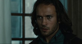 Movie still from “Queen Margot” (1994), directed by Patrice Chéreau – A person with long dark hair; Close Up shot, Over the shoulder angle