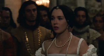 Movie still from “Queen Margot” (1994), directed by Patrice Chéreau – A woman in a white dress and pearls in a crowd; Close Up shot, Over the shoulder angle