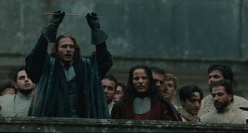 Movie still from “Queen Margot” (1994), directed by Patrice Chéreau – A group of people standing next to each other on a wall; Medium shot, Low angle