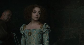 Movie still from “Queen Margot” (1994), directed by Patrice Chéreau – A woman in a green and gold dress looking to her left; Close Up shot, Over the shoulder angle