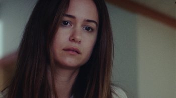 Movie still from “Queen of Earth” (2015), directed by Alex Ross Perry – A person with long brown hair; Close Up shot, Over the shoulder angle