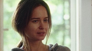 Movie still from “Queen of Earth” (2015), directed by Alex Ross Perry – A person with long brown hair; Close Up shot, Over the shoulder angle