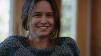 Movie still from “Queen of Earth” (2015), directed by Alex Ross Perry – A person wearing a sweater smiling; Close Up shot, Over the shoulder angle