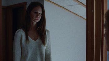 Movie still from “Queen of Earth” (2015), directed by Alex Ross Perry – A woman standing in front of a mirror in a room; Medium shot, Low angle