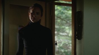 Movie still from “Queen of Earth” (2015), directed by Alex Ross Perry – A woman standing in front of an open window; Medium shot, Over the shoulder angle