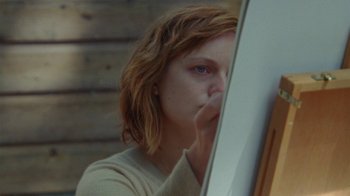 Movie still from “Queen of Earth” (2015), directed by Alex Ross Perry – A woman looking at her reflection in a mirror; Close Up shot, Low angle