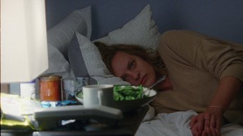 Movie still from “Queen of Earth” (2015), directed by Alex Ross Perry – A woman laying in bed with a bowl of salad on a tray; Medium shot, High angle