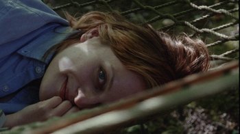 Movie still from “Queen of Earth” (2015), directed by Alex Ross Perry – A woman laying on the ground with her head resting on her hands; Close Up shot, Overhead angle