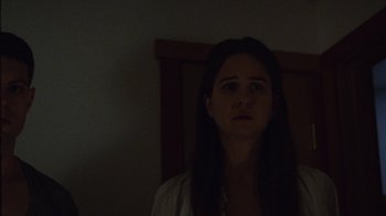 Movie still from “Queen of Earth” (2015), directed by Alex Ross Perry – A woman standing in a dark room with her head on a table; Close Up shot, Low angle