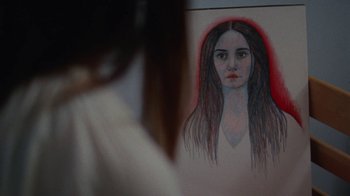 Movie still from “Queen of Earth” (2015), directed by Alex Ross Perry – A drawing of a woman with long hair; Extreme Close Up shot, Over the shoulder angle