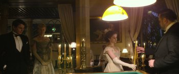 Movie still from “Queen of the Desert” (2015), directed by Werner Herzog – A woman in a white dress standing at a bar; Medium shot, Low angle