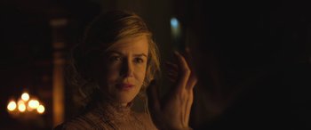 Movie still from “Queen of the Desert” (2015), directed by Werner Herzog – A beautiful blonde haired woman in a dark room; Close Up shot, Over the shoulder angle