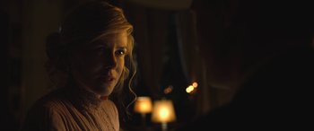 Movie still from “Queen of the Desert” (2015), directed by Werner Herzog – A person in a room lit by a lamp; Close Up shot, Over the shoulder angle