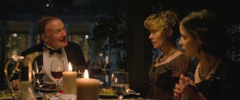 Movie still from “Queen of the Desert” (2015), directed by Werner Herzog – A woman sitting at a table with a glass of red wine; Close Up shot, Over the shoulder angle