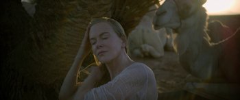 Movie still from “Queen of the Desert” (2015), directed by Werner Herzog – A beautiful woman with her eyes closed under an umbrella; Close Up shot, Over the shoulder angle