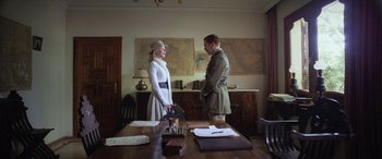 Movie still from “Queen of the Desert” (2015), directed by Werner Herzog – A man and a woman standing next to each other in front of a desk; Medium shot, Over the shoulder angle