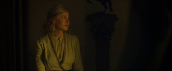 Movie still from “Queen of the Desert” (2015), directed by Werner Herzog – A woman is standing in a dark room; Medium shot, Low angle