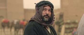 Movie still from “Queen of the Desert” (2015), directed by Werner Herzog – A man with a long beard wearing a turban; Close Up shot, Over the shoulder angle